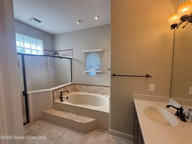 a bathroom with a tub sink and mirror