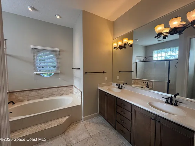 a bathroom with a tub a sink and mirror