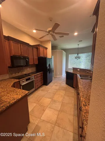 a kitchen with stainless steel appliances granite countertop a refrigerator and a stove top oven