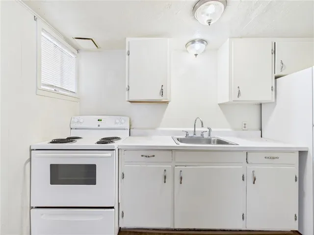 a kitchen with cabinets appliances a sink and a counter top space
