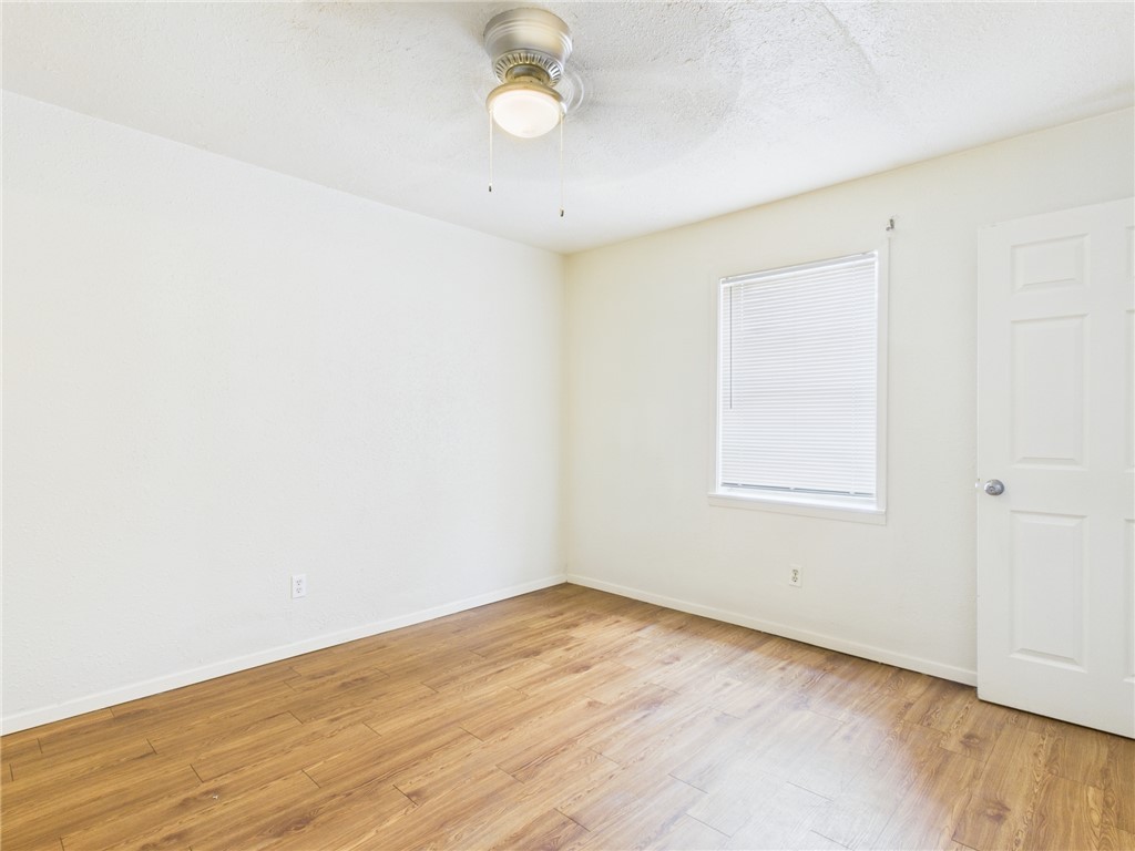 308 Ehlinger Drive, Unit C Bryan, TX 77801 - Photo 8 of 15 an empty room with wooden floor and windows