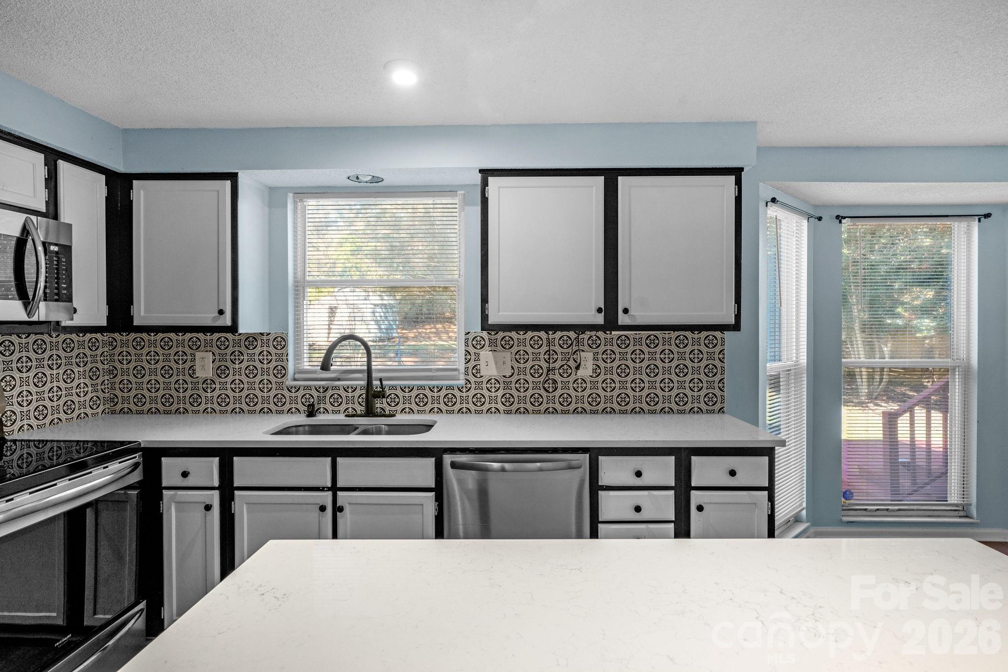 12006 Woodside Falls Road Pineville, NC 28134 - Photo 14 of 48 a kitchen with a sink a stove and cabinets