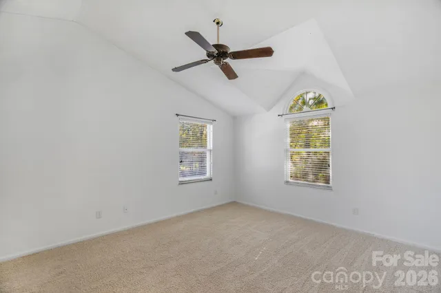 an empty room with a window and ceiling fan