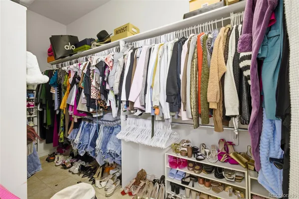 a view of walk in closet with clothes and shoes