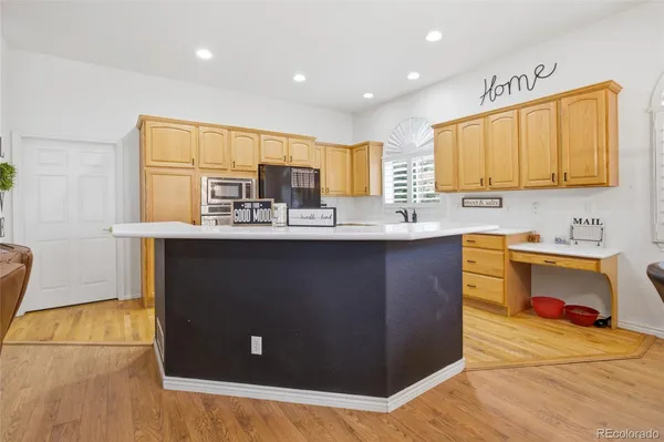 a kitchen with kitchen island granite countertop a sink a counter top space and cabinets