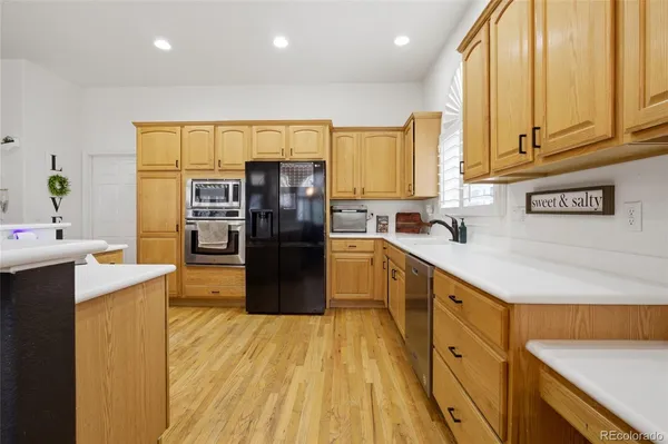 a kitchen with stainless steel appliances a refrigerator sink and wooden cabinets