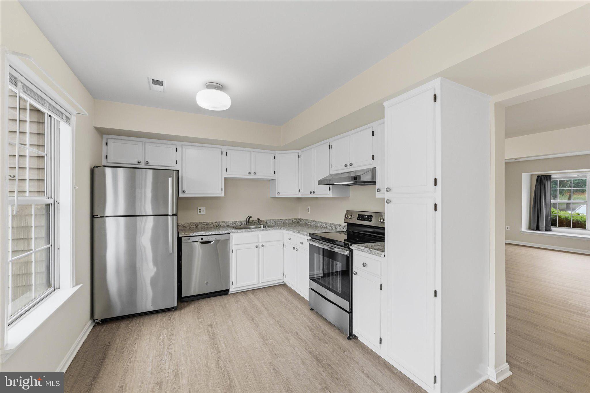 2753 Bixby Road Woodbridge, VA 22193 - Photo 4 of 22 a kitchen with stainless steel appliances white cabinets and wooden floors