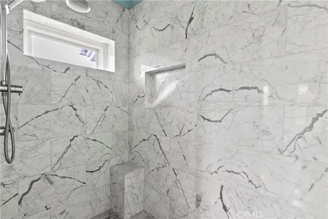 a bedroom with furniture and a large window