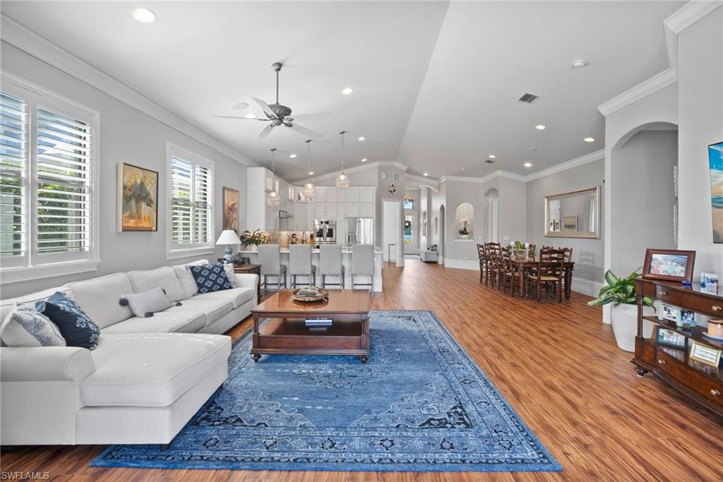 10340 Vanderbilt Drive Naples, FL 34108 - Photo 16 of 45 a living room with furniture kitchen view and a wooden floor