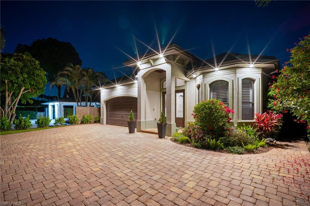 10340 Vanderbilt Drive Naples, FL 34108 - Photo 2 of 45 a front view of a house with a yard