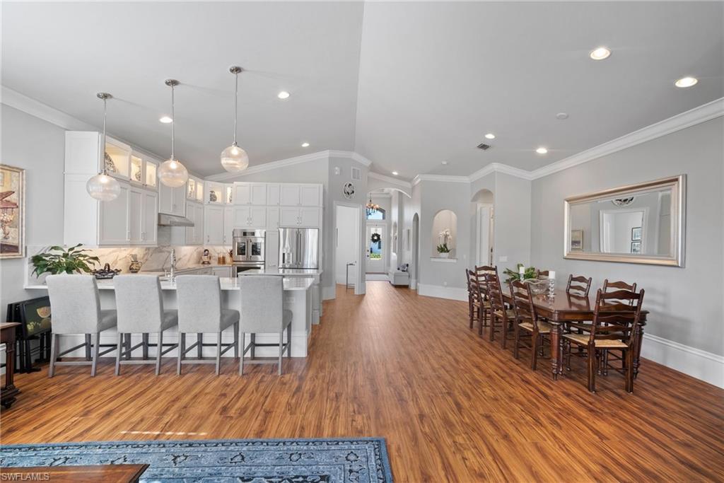 10340 Vanderbilt Drive Naples, FL 34108 - Photo 21 of 45 a view of a dining room with furniture and wooden floor