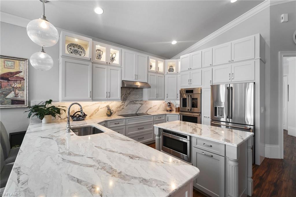 10340 Vanderbilt Drive Naples, FL 34108 - Photo 22 of 45 a kitchen with stainless steel appliances kitchen island granite countertop a stove refrigerator and cabinets