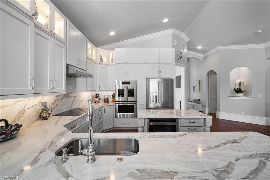 10340 Vanderbilt Drive Naples, FL 34108 - Photo 23 of 45 a kitchen with stainless steel appliances kitchen island granite countertop a refrigerator and microwave