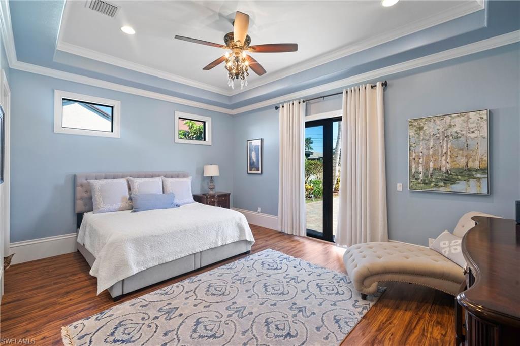 10340 Vanderbilt Drive Naples, FL 34108 - Photo 26 of 45 a bedroom with a bed and a chandelier