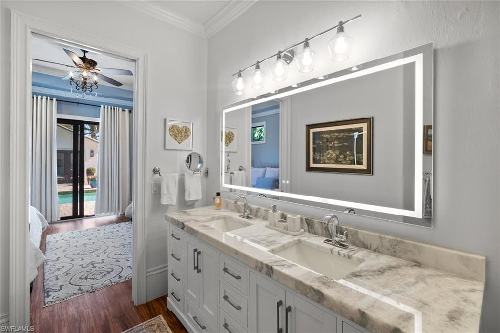 10340 Vanderbilt Drive Naples, FL 34108 - Photo 29 of 45 a bathroom with double vanity sinks a vanity a lamp and a mirror