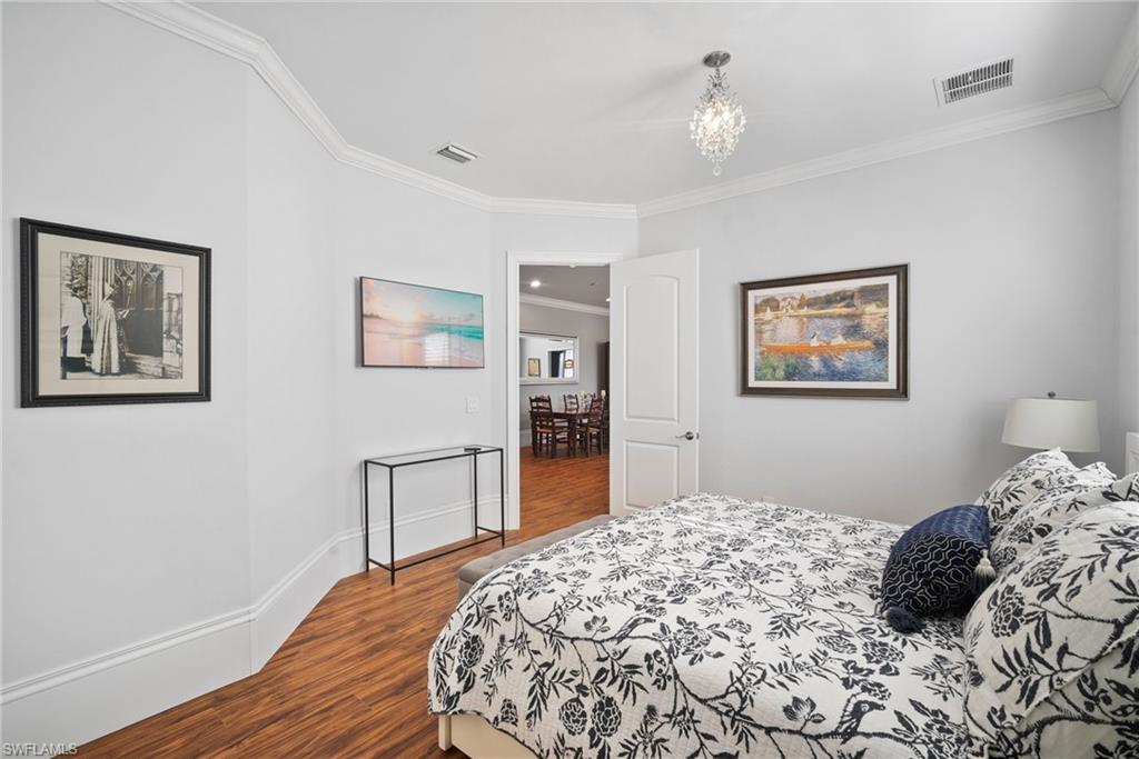 10340 Vanderbilt Drive Naples, FL 34108 - Photo 33 of 45 a bedroom with bed and wooden floor