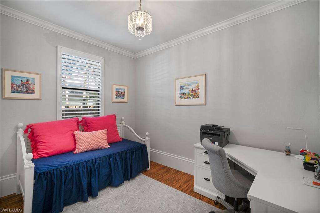 10340 Vanderbilt Drive Naples, FL 34108 - Photo 34 of 45 a bedroom with a bed and wooden floor