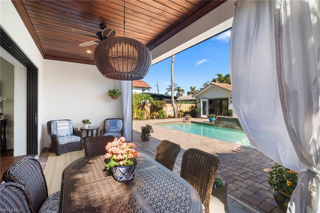 10340 Vanderbilt Drive Naples, FL 34108 - Photo 41 of 45 a living room with furniture and a chandelier