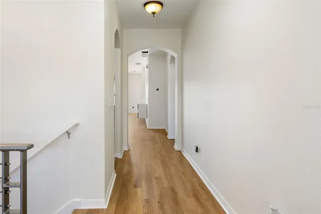 a view of a hallway with wooden floor and staircase