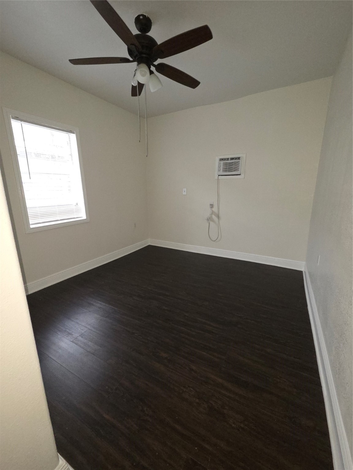 7902 Hudson Street, Unit B Houston, TX 77012 - Photo 6 of 6 an empty room with wooden floor fan and windows