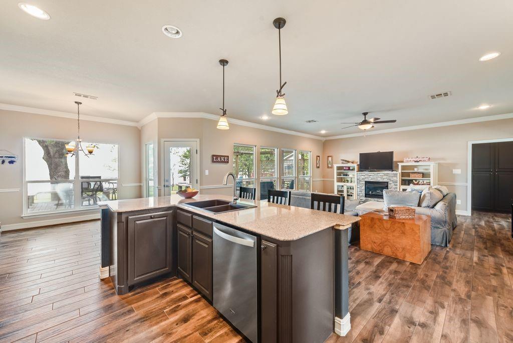 13026 Rudy's Way Streetman, TX 75859 - Photo 14 of 40 a kitchen with stainless steel appliances granite countertop a sink a stove and a wooden floor