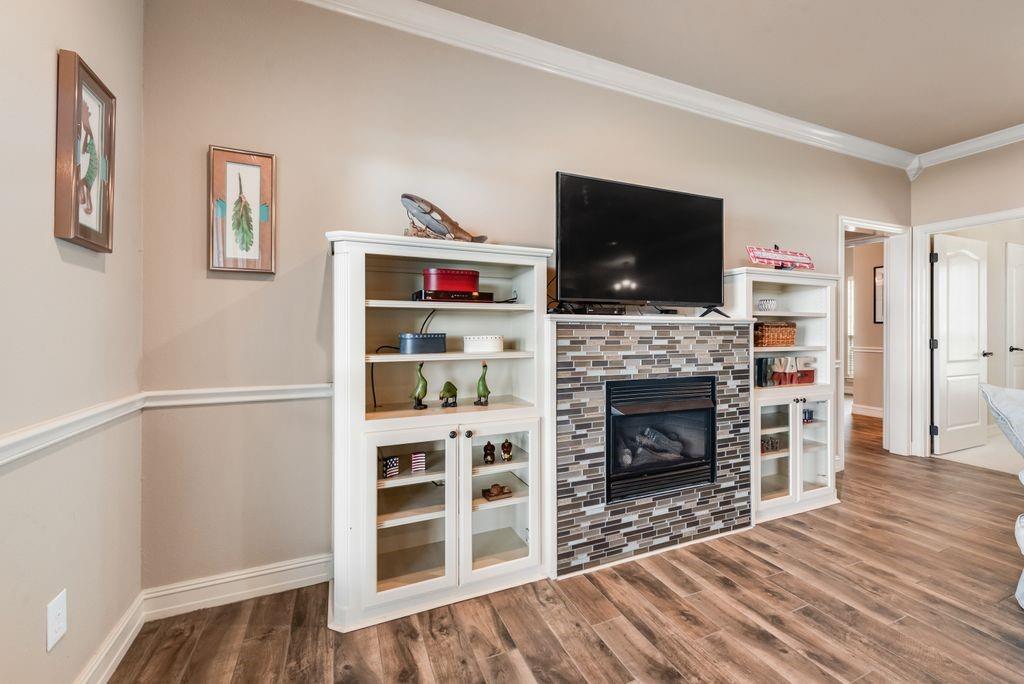 13026 Rudy's Way Streetman, TX 75859 - Photo 10 of 40 a living room with a fireplace and a flat screen tv