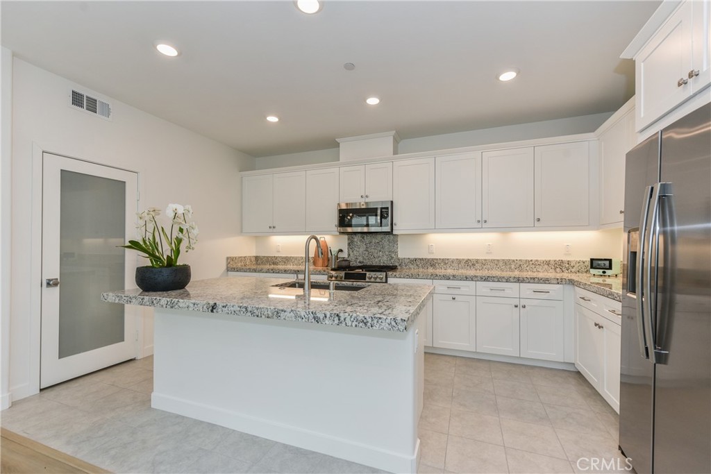 224 Siena Lake Forest, CA 92630 - Photo 14 of 46 a kitchen with stainless steel appliances granite countertop a sink a stove and a refrigerator