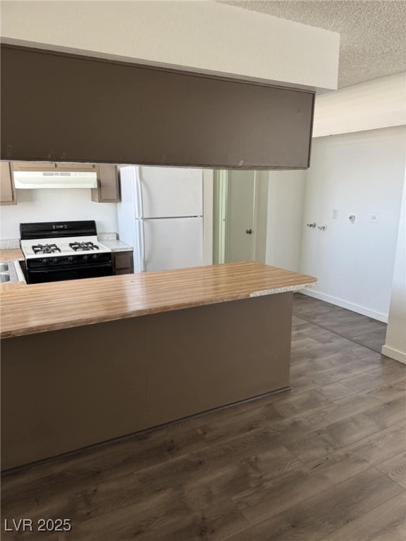 2377 Exeter Drive, Unit 3 Las Vegas, NV 89156 - Photo 11 of 13 Kitchen featuring gas range oven, freestanding refrigerator, dark wood-type flooring, under cabinet range hood, and a textured ceiling