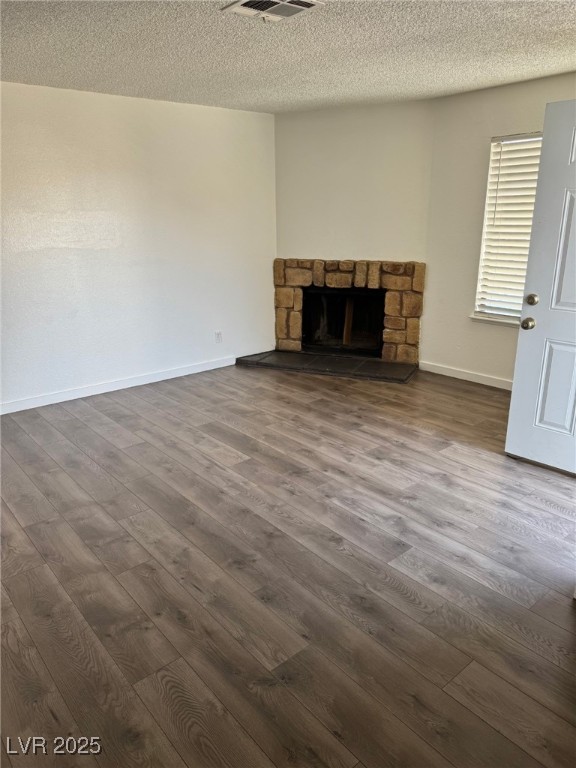 2377 Exeter Drive, Unit 3 Las Vegas, NV 89156 - Photo 6 of 13 Unfurnished living room with a fireplace, dark wood-style flooring, and a textured ceiling