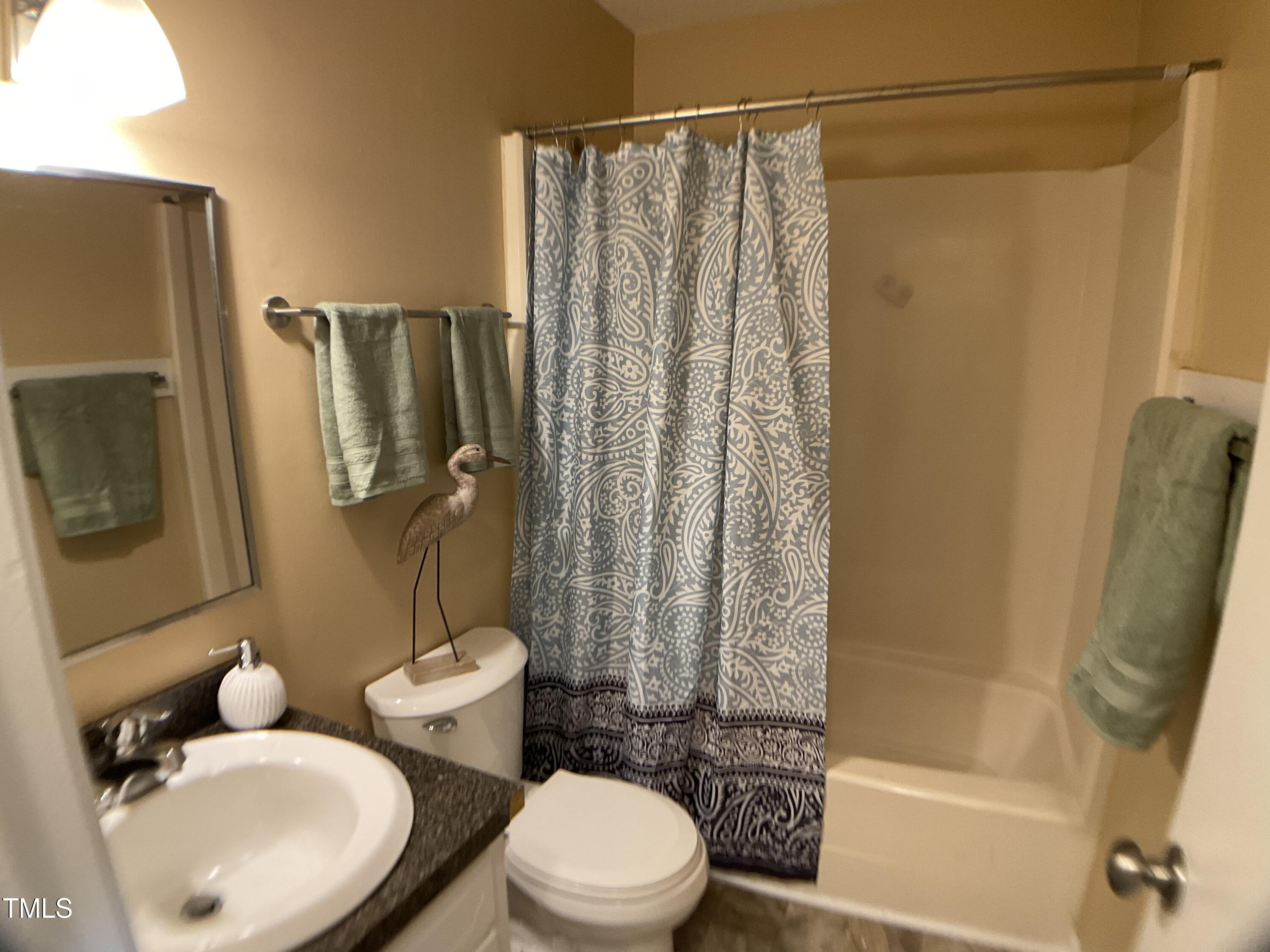 2915 Ross Road Durham, NC 27703 - Photo 9 of 21 a white toilet sitting next to a bathroom sink and shower