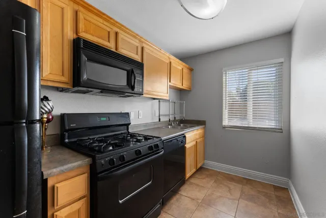 a kitchen with stainless steel appliances granite countertop a stove a microwave and a sink