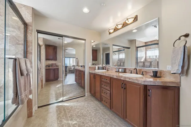 a large bathroom with a large mirror vanity and shower