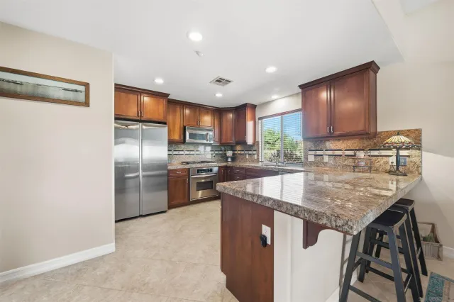 a kitchen with stainless steel appliances granite countertop a sink stove and refrigerator