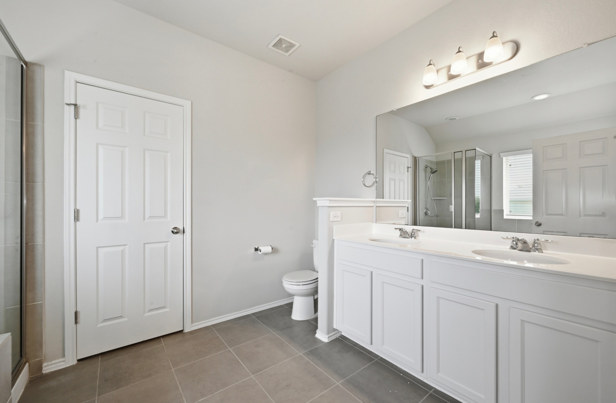 209 Noddy Road Buda, TX 78610 - Photo 19 of 30 Spacious bathroom featuring a dual vanity with white cabinetry, light countertops, and a large wall-mounted mirror