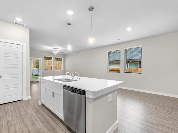 a kitchen with a sink and wooden floor