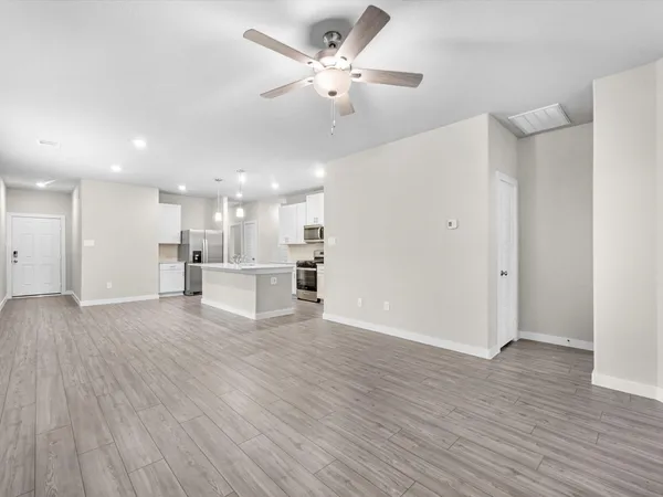 a view of an empty room with wooden floor