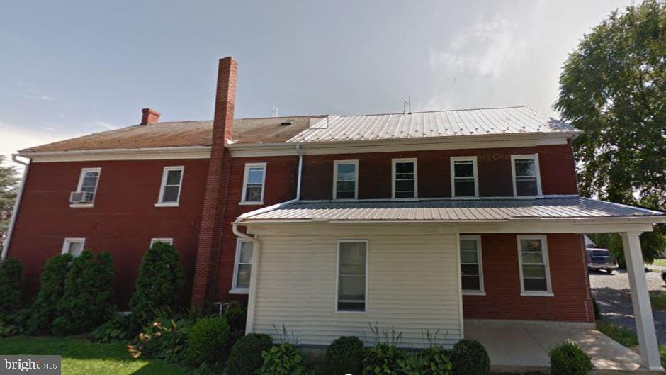 a front view of a house with plants