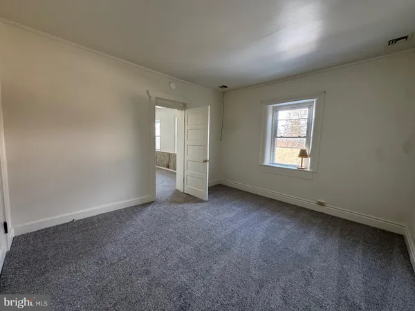 an empty room with fan and windows