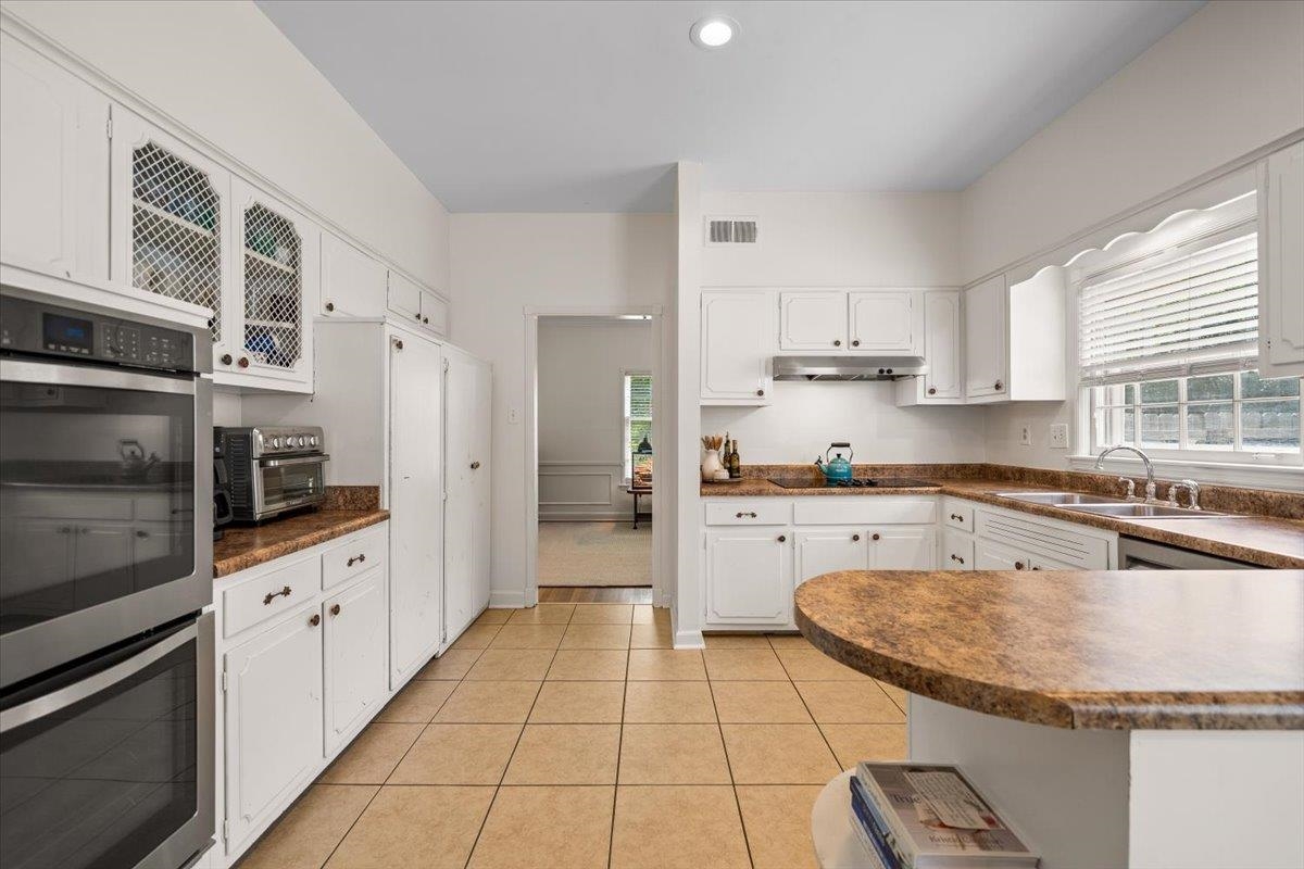 1273 Brookfield Road Memphis, TN 38119 - Photo 16 of 40 Kitchen featuring white cabinetry, light-toned tiled flooring, and neutral-toned countertops