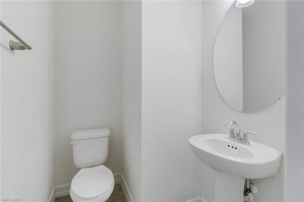 7948 Bristol Circle Naples, FL 34120 - Photo 17 of 27 a bathroom with a sink a toilet and mirror