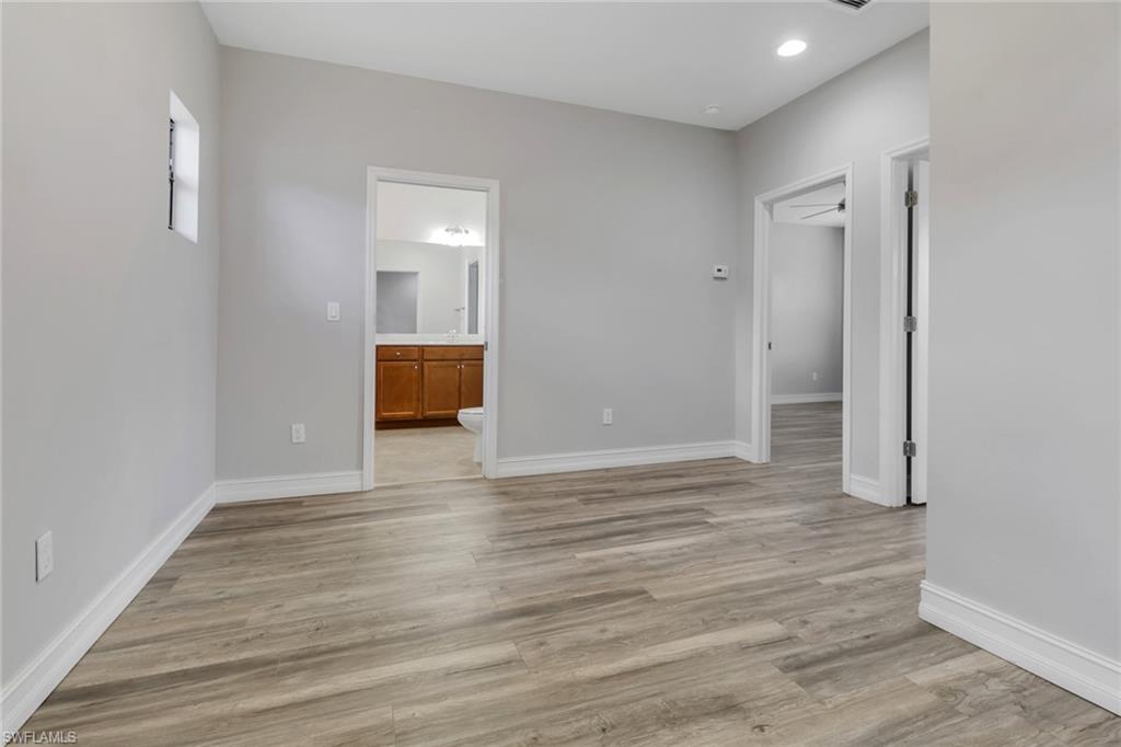 7948 Bristol Circle Naples, FL 34120 - Photo 19 of 27 a view of an empty room with wooden floor and a window