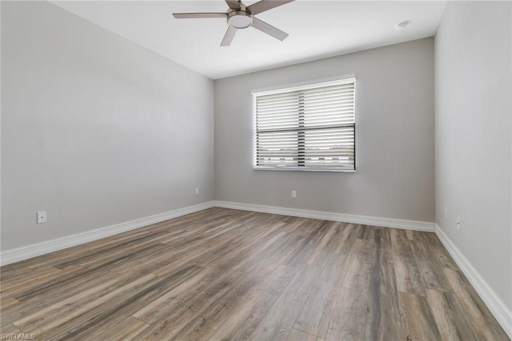 7948 Bristol Circle Naples, FL 34120 - Photo 20 of 27 wooden floor in an empty room with a window