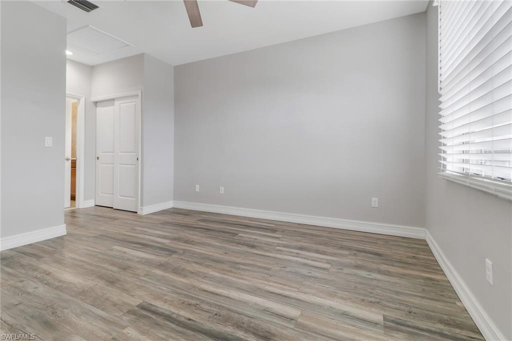 7948 Bristol Circle Naples, FL 34120 - Photo 21 of 27 a view of an empty room with wooden floor and a window