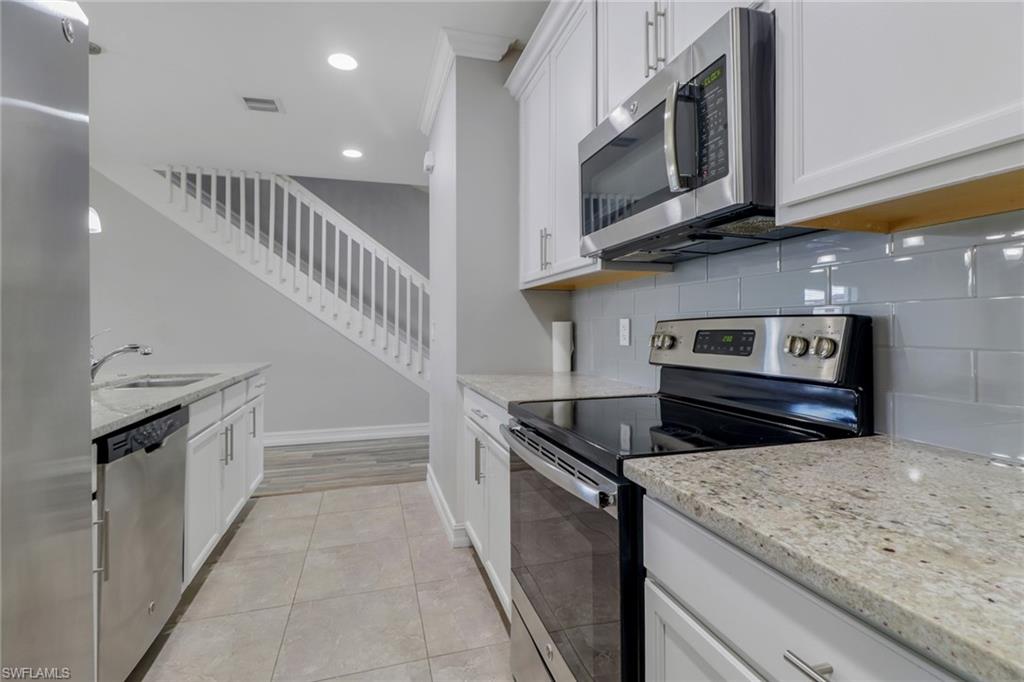 7948 Bristol Circle Naples, FL 34120 - Photo 6 of 27 a kitchen with granite countertop a stove and a microwave