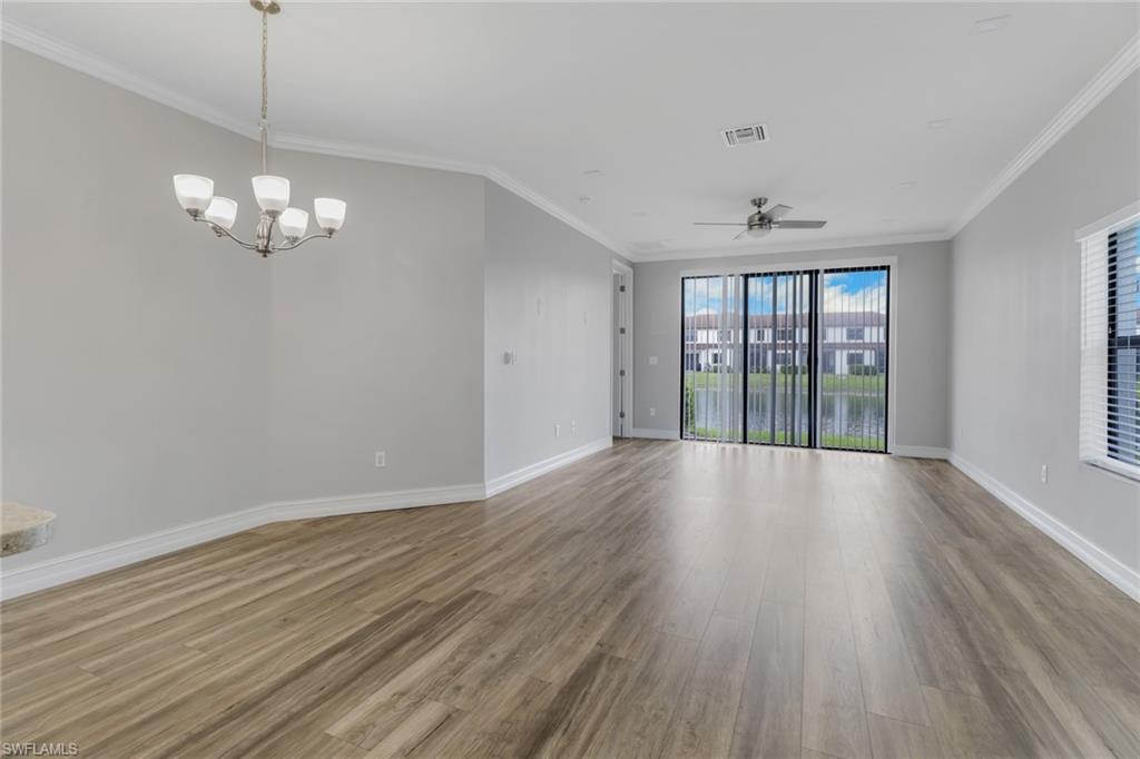 7948 Bristol Circle Naples, FL 34120 - Photo 9 of 27 a view of a room with wooden floor and chandelier