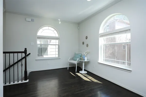 an empty room with chandelier fan and windows