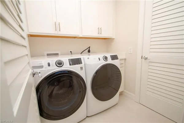 a view of washer and dryer with kitchen in the background