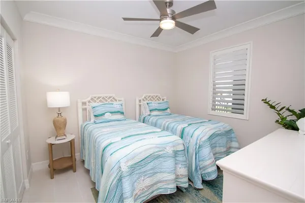 a bedroom with two beds and a chandelier