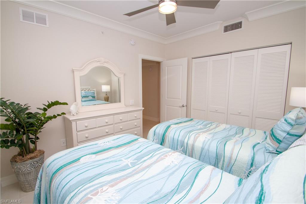 232 Indies Drive East, Unit 101 Naples, FL 34114 - Photo 16 of 50 a bedroom with two beds and a potted plant