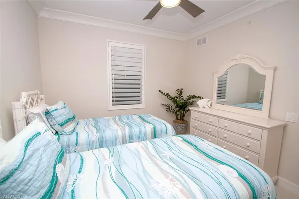 a bedroom with two beds and a potted plant